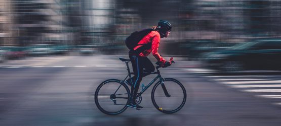 a boy rides bike fast in the big city