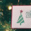 a christmas card hanging on christmas tree