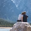 a college couple admiring mountain rocks at the lake