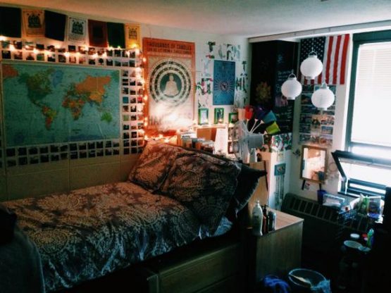 a dorm room decorated with wall posters