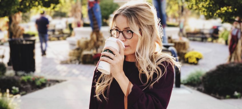 a girl drinking a cup of coffee from Starbucks