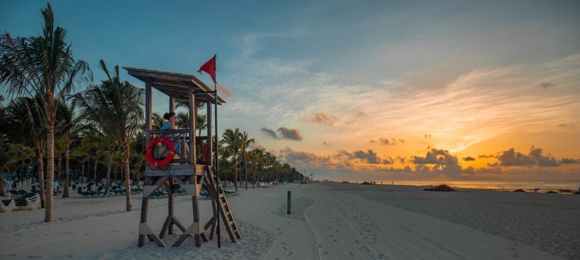 a girl is looking at the sea at lifeguard tower