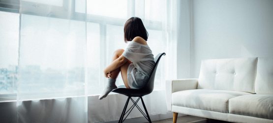 a girl sitting in the white room alone