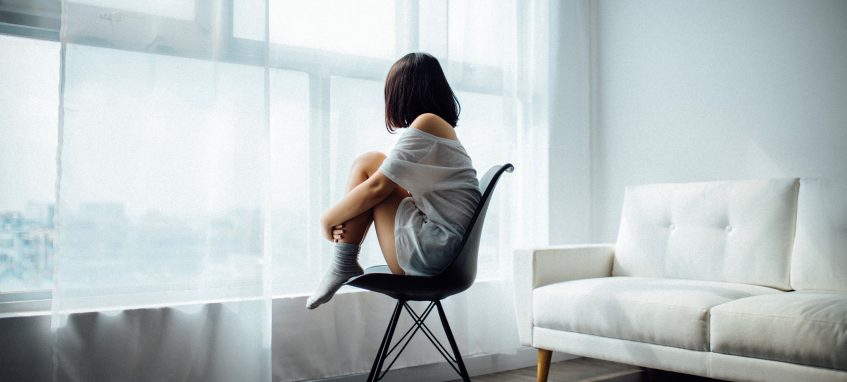 a girl sitting in the white room alone