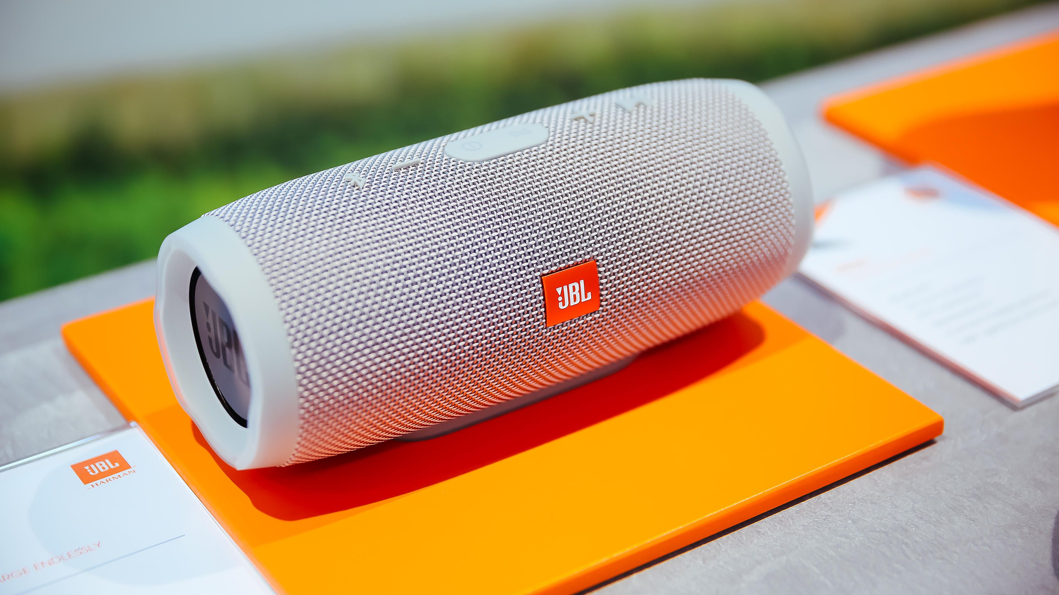 a grey bluetooth speaker on an orange mat