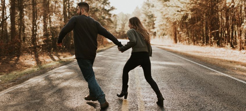 a guy and a girl run towards the wood