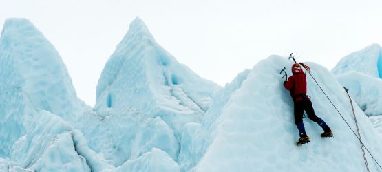 a guy climbing a mountain covered with ice