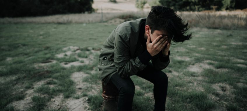 a guy holding his face in hands in despair