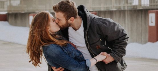 a guy kissing a girl on the roof