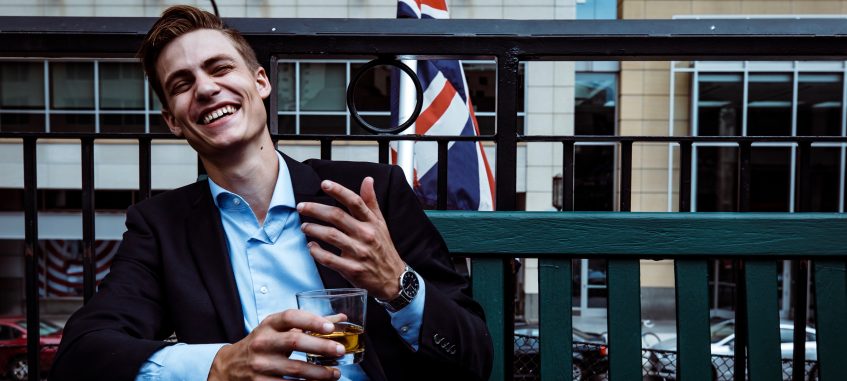 a guy sits on the bench near the British flag