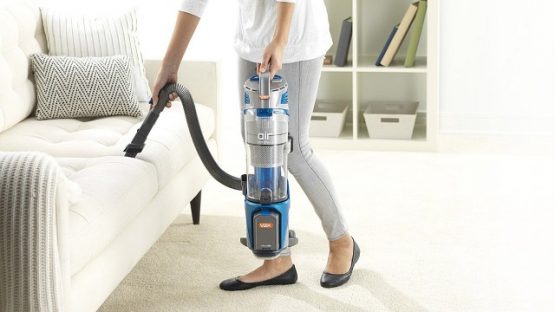 a woman using a portable vacuum cleaner in the living room