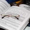 glasses lying on top of the opened book