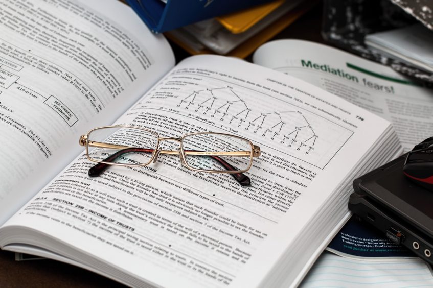 glasses lying on top of the opened book