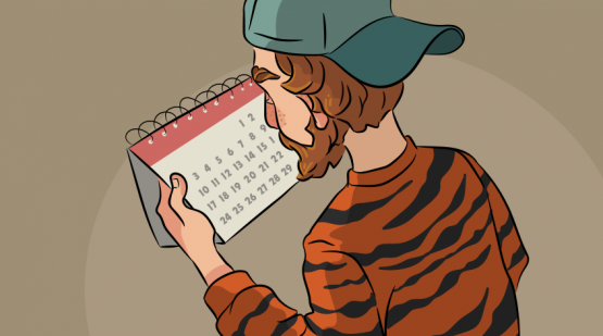 a guy in a tiger sweater looking at a calendar