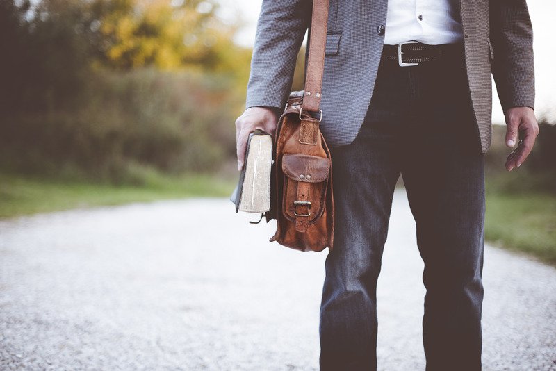 a guy standing with a book in a hand