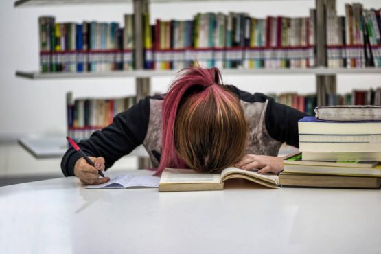 a girl sleeping in a library