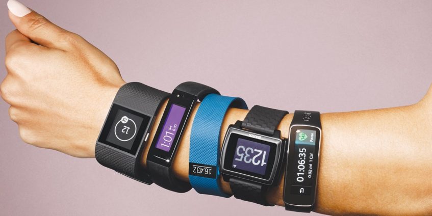 five fitness trackers of different types on one hand