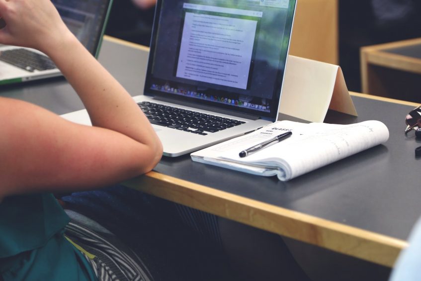 woman sitting in fron of opened dfile on the laptop