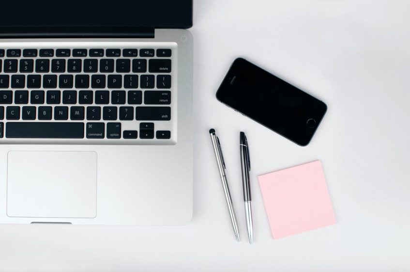 a laptop and pens on a table