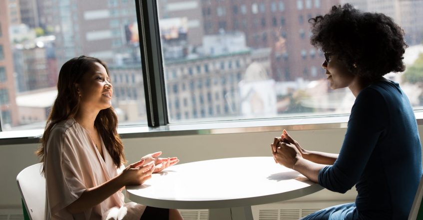 two girls talking next to video