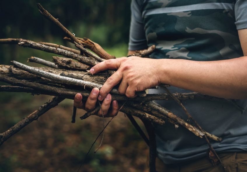 a guy holding a bunch of sticks