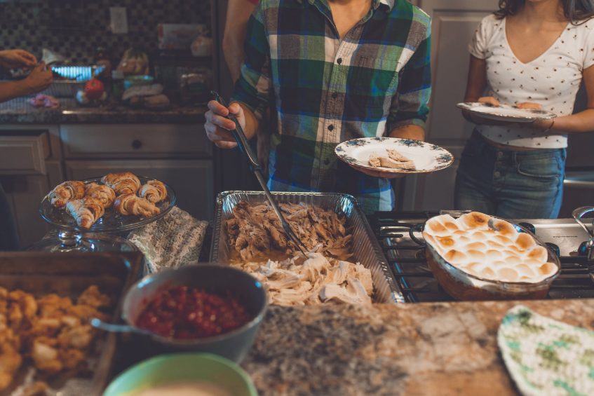 a guy standing next to table full of food