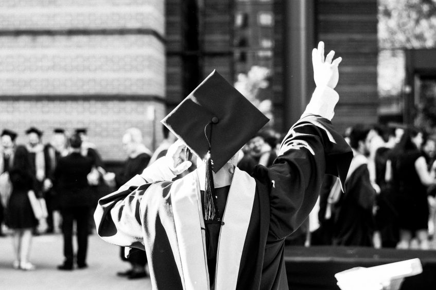 a graduation student waves at someone