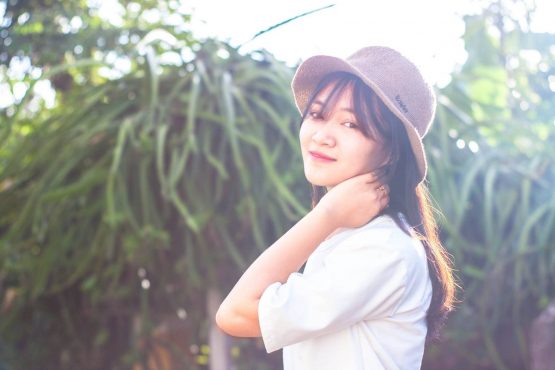asian girl in a hat smiling in a summy day