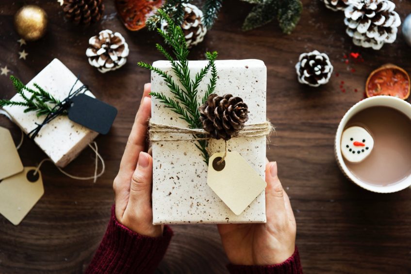 a wrapped gift with pine cones and craft paper