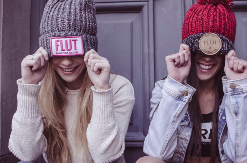 two girls in knitted hats smiling