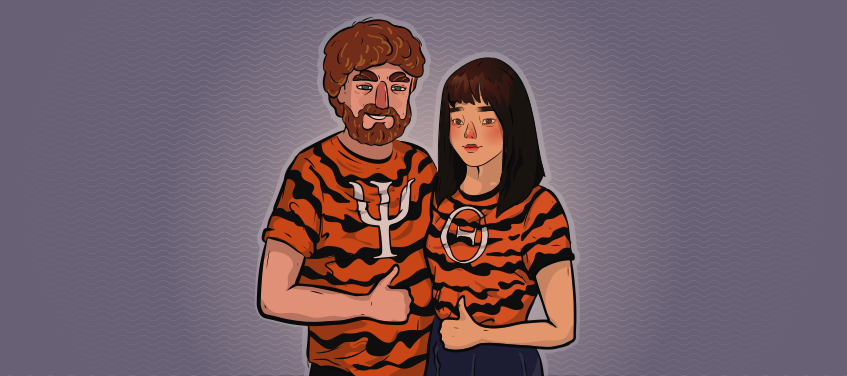 a girl and a guy in tiger shirts with greek letters are hugging