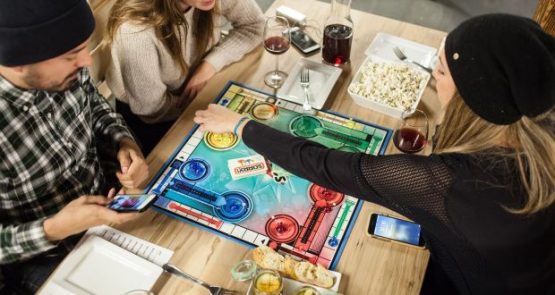 three students are playing board games and drinking wine