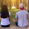 young couple sitting on the bench in the wood